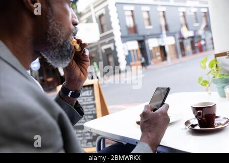 Homme afro-américain passant du temps sur une terrasse de café Banque D'Images