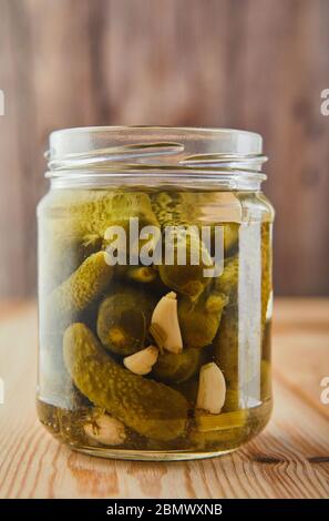Concept végétarien fermenté conservé. Cornichons dans un pot en verre sur une table de cuisine en bois. Le concept de la nourriture en conserve. Copier l'espace Banque D'Images