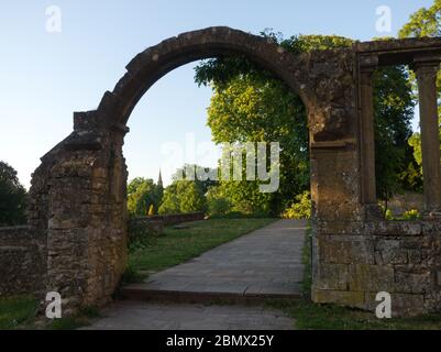 Vue sur un jardin de la ville par une porte en ruines à Metz France Banque D'Images