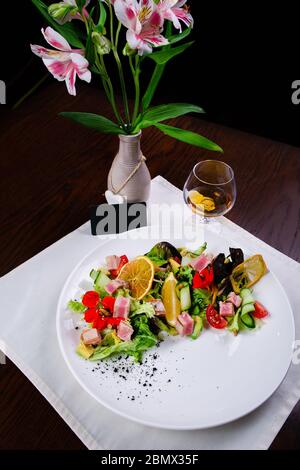 Plat avec une salade saine pour le dîner avec tomate, saucisse, jambon, brocoli et haricots Banque D'Images