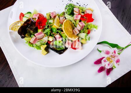 Plat avec une salade saine pour le dîner avec tomate, saucisse, jambon, brocoli et haricots Banque D'Images