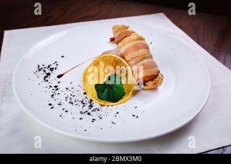 Filet mignon grillé, enveloppé de bacon, avec légumes grillés, beurre et rosemarie sur une assiette blanche Banque D'Images