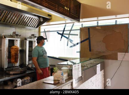 Waldkraiburg, Allemagne. 11 mai 2020. Le propriétaire d'un snack-bar kebab, Hasan Cavus, se trouve devant les fenêtres détruites de son magasin. Selon les enquêteurs, une série d'attaques contre les magasins turcs de Waldkraiburg a été résolue. Un homme de 25 ans a avoué ces crimes. Credit: Angelika Warmuth/dpa/Alamy Live News Banque D'Images