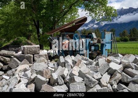 coupez des pierres et des blocs avec une vieille machine de coupe de roche en arrière-plan Banque D'Images