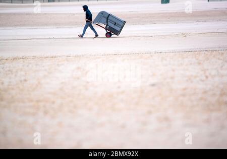 Rostock, Allemagne. 11 mai 2020. Un propriétaire utilise une voiturette pour apporter une chaise de plage en osier à son espace de stationnement à la plage de Warnemünde. Après un renouveau de desserrage de la couronne, les meubles de plage peuvent maintenant être loués à nouveau aux vacanciers et aux baigneurs. Cependant, en raison du temps froid et orageux avec des températures autour de huit degrés, il n'y avait presque pas de visiteurs sur la côte de la mer Baltique. Credit: Jens Büttner/dpa-Zentralbild/dpa/Alay Live News Banque D'Images