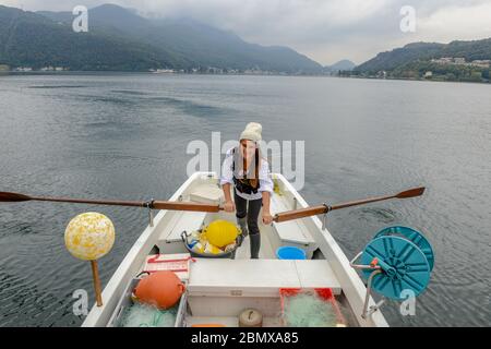 Lugano, Suisse - 18 Oktober 2016: Femme dans son bateau de pêche sur le lac de Lugano, en Suisse Banque D'Images