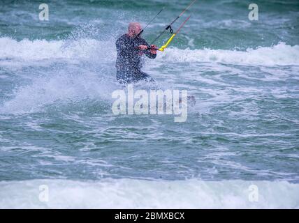 Rostock, Allemagne. 11 mai 2020. Les surfeurs de cerf-volant sont dehors et autour avec leurs cerfs-volants sur la mer Baltique au large de Warnemünde par temps orageux. Le temps est froid et très venteux au printemps de mai avec des températures autour de huit degrés. Credit: Jens Büttner/dpa-Zentralbild/dpa/Alay Live News Banque D'Images