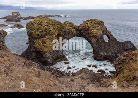 Gatklettur ('Arc Hellnar'), une superbe arche de roche et un littoral de basalte à Arnarstapi, péninsule de Snæfellsnes, Islande. Banque D'Images