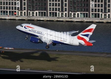 British Airways Airbus A318 décollage de l'aéroport de London City avec Suburbia en arrière-plan Banque D'Images