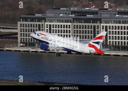 British Airways Airbus A318 décollage de l'aéroport de London City avec Suburbia en arrière-plan Banque D'Images