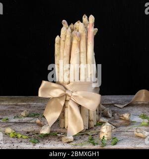 asperges blanches vue latérale sur une table en bois avec fond noir Banque D'Images