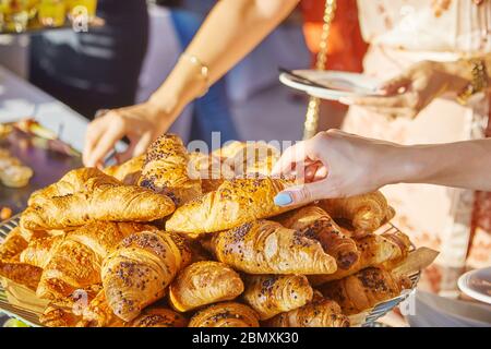 Des femmes prennent des croissants lors d'un banquet lors d'une conférence Banque D'Images