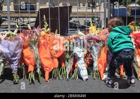 Un petit garçon dépose des fleurs à l'extérieur de l'hôtel de ville du Cap le 6 décembre 2013, le lendemain de la mort de l'ancien président, l'Afrique du Sud Banque D'Images