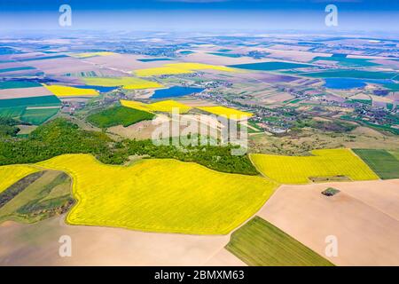 Paysage rural aérien en Roumanie, champs de canola, forêt, villages et lacs Banque D'Images