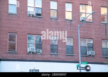 Un panneau dans la fenêtre disant «l'amour l'un l'autre» sur le Bowery à New York. Banque D'Images