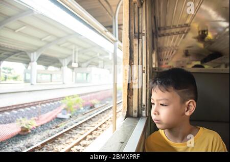 Portrait d'un garçon sur le train regardant à l'extérieur de la fenêtre vues Banque D'Images