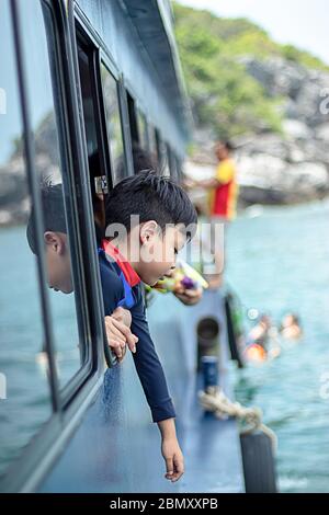 Portrait de l'Asie sur la fenêtre garçon bateau dans la mer. Banque D'Images