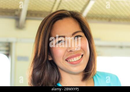 Portrait d'une femme asiatique souriante dans un train. Banque D'Images