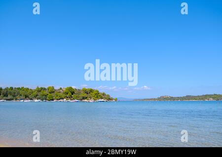 Paysage d'eau turquoise avec colline verte en arrière-plan et ciel bleu pendant la journée d'été Banque D'Images