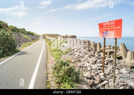 Piste cyclable sur la North Wales Expressway. Panneau d'avertissement pour tenir loin des roches et des unités de béton (dolos / dolosse) Banque D'Images