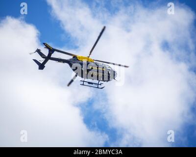 BIDEFORD, DEVON, ANGLETERRE, Royaume-Uni - MAI 11 2020 : un hélicoptère de police bleu et jaune patrouille le ciel du nord du Devon. Banque D'Images