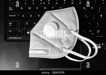 Masque de protection Cinavirus Covid-19 KN95 placé sur un clavier d'ordinateur portable Banque D'Images