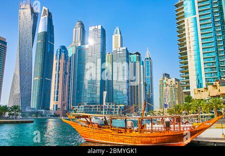 DUBAÏ, Émirats Arabes Unis - 2 MARS 2020 : la fusion des technologies modernes et du style de vie traditionnel dans la marina de Dubaï - le bateau de dhow en bois vintage devant le Banque D'Images