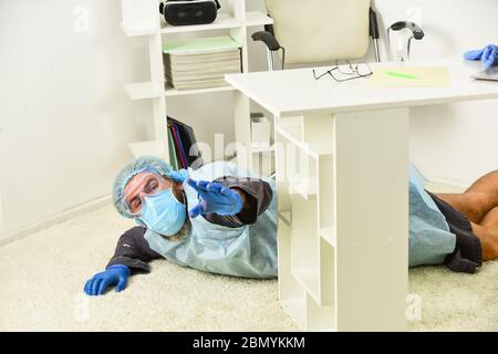 Malade sans défense. Fièvre et faiblesse. Maladie grave et décès. Homme est décédé. Essoufflement. Homme dans l'équipement de protection posé sur le sol. État grave du patient. L'automédication est dangereuse. Banque D'Images