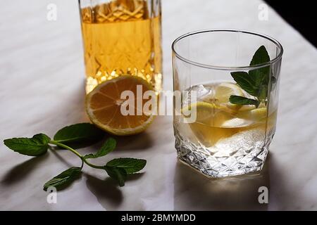 le rhum avec citron glacé et menthe est sur une table lumineuse Banque D'Images