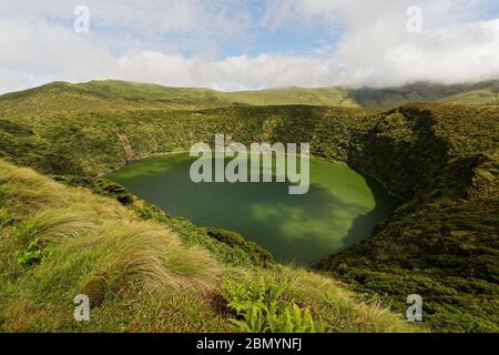 Lac cratère entouré d'une végétation luxuriante, au-dessus d'une formation de nuages qui jette une ombre frappante sur la surface de l'eau - lieu: Portugal, Açores, Flo Banque D'Images
