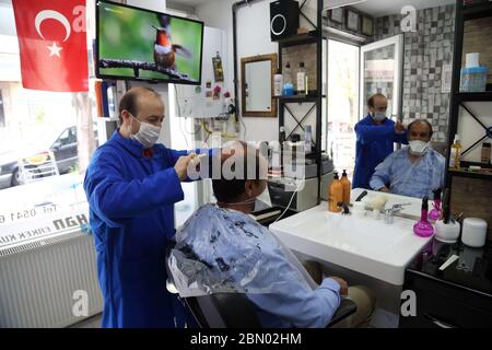 Ankara, Turquie. 11 mai 2020. Un coiffeur portant un masque fait une coupe de cheveux pour un client dans un salon de coiffure à Ankara, Turquie, le 11 mai 2020. La Turquie a signalé 1,114 nouveaux cas de COVID-19 et 55 autres décès lundi, portant le nombre total de cas confirmés à 139,771 et le nombre de décès à 3,841. Crédit: Mustafa Kaya/Xinhua/Alamy Live News Banque D'Images