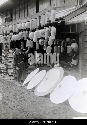 [ années 1920 Japon - Lanterne et parasol japonais ] — Boutique vendant lanternes et parasols en papier. Comme les deux étaient en papier, ils étaient habituellement produits dans le même atelier. imprimé gélatine argent du xxe siècle. Banque D'Images