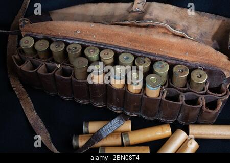 bandolier de chasse en cuir brun vintage avec cartouches sur fond noir Banque D'Images