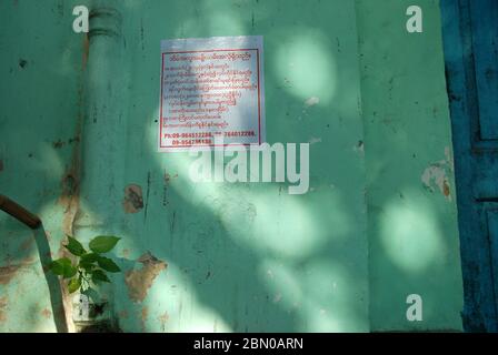 Panneau sur le mur vert, Yangon, Myanmar, Asie. Banque D'Images