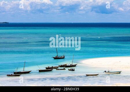 Bateaux de pêche dans l'eau turquoise verte sur la plage de Kendwa, Zanzibar, Tanzanie Banque D'Images