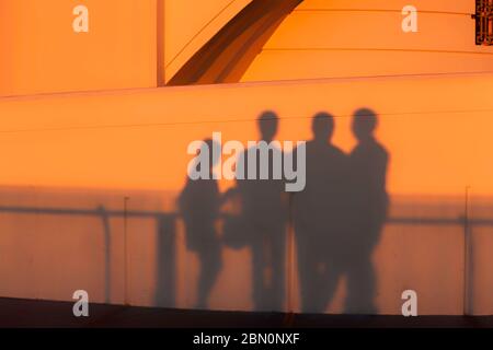 Les visiteurs jettent des ombres sur le mur de l'observatoire Griffith Park au coucher du soleil tout en observant la couleur de Los Angeles, Californie, États-Unis Banque D'Images