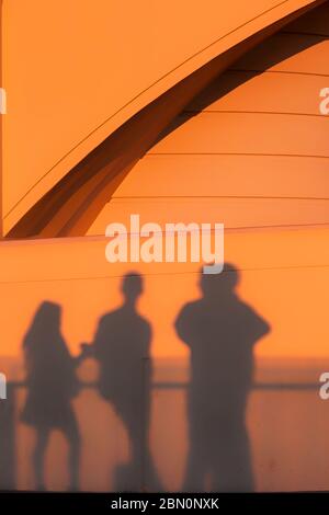 Les visiteurs jettent des ombres sur le mur de l'observatoire Griffith Park au coucher du soleil tout en observant la couleur de Los Angeles, Californie, États-Unis Banque D'Images