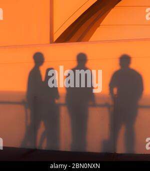 Les visiteurs jettent des ombres sur le mur de l'observatoire Griffith Park au coucher du soleil tout en observant la couleur de Los Angeles, Californie, États-Unis Banque D'Images