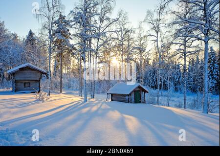 Chalets en rondins dans un éclairage hivernal étincelant, Boda kyrkby, Rättvik, Dalarna, Suède Banque D'Images