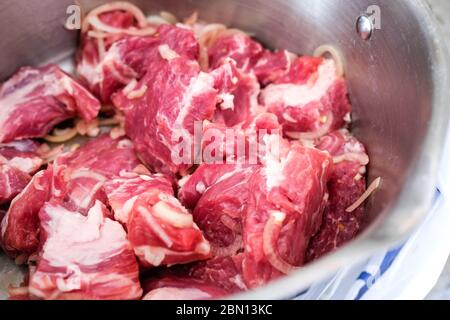 Viande rouge crue pour barbecue dans une assiette. Porc coupé en tranches avec des oignons. Banque D'Images