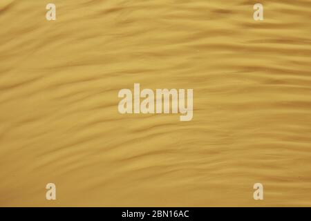 Arrière-plan rayé ondulé jaune. Vagues et ondulations sur l'eau. Place pour le texte et la conception. Banque D'Images