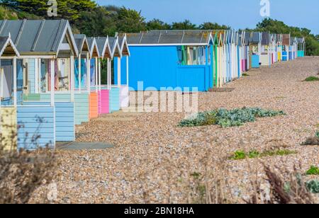 Rangée de vieilles cabanes de plage multicolores sur une plage de galets à Norfolk Arms, West Sussex, Angleterre, Royaume-Uni. Banque D'Images