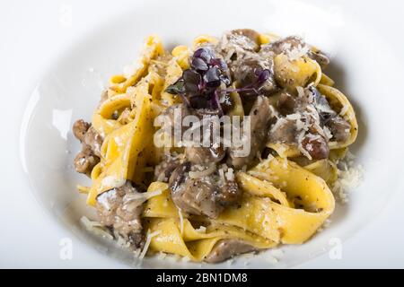 Pâtes pamppardelles fraîches aux champignons porcini et senteur truffe. Plat italien traditionnel cuit dans le style italien et les épices. Parmesan et mozzarella Banque D'Images