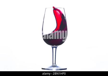 vague de vin rouge dans un verre isolé sur fond blanc Banque D'Images