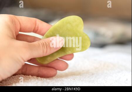 Masseur pour le visage gua sha vert pour femme Banque D'Images