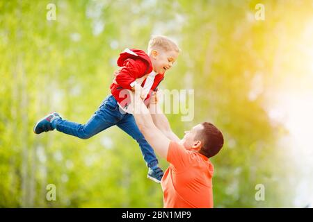 Concept de famille heureuse. Père et fils ont du plaisir dans le parc d'été, papa tiennent le patin dans les bras. Banque D'Images