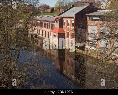 Anciens bâtiments d'usine en briques rouges se reflétant dans les eaux de la rivière Akerselva à Sagene, Oslo en Norvège Banque D'Images