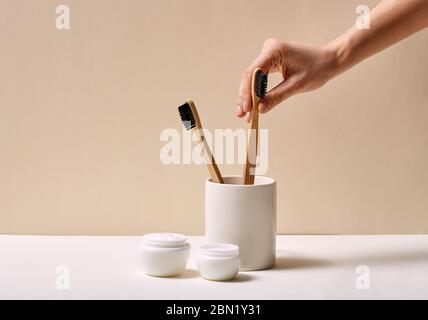 Concept écologique. Brosses à dents en bambou dans un savon crème pour le visage et une serviette isolés dans la salle de bains de près Banque D'Images