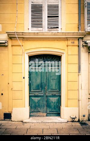 Portes en bois peint en vert d'une maison peinte en jaune à Aix en Provence, France Banque D'Images