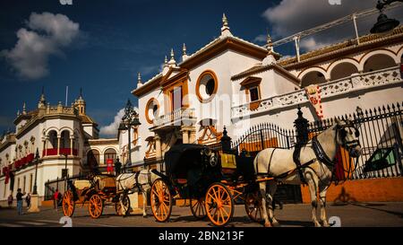 Séville, Espagne - 20 février 2020 - la Plaza de Toros de Séville avec sa façade de style baroque architectural et ses calèches attendent Banque D'Images